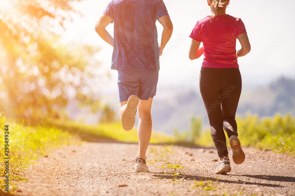 young couple jogging on sunny day at nature - obrazy, fototapety, plakaty 