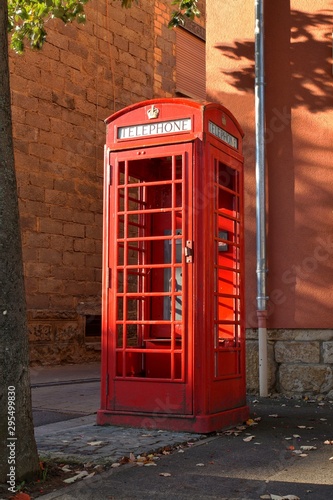 Classic English K6 red phone box with eight glass windows. London Phone Booth, Red cabin with destroyed windows. Symbol of the UK. The word Telephone, written beneath a crown