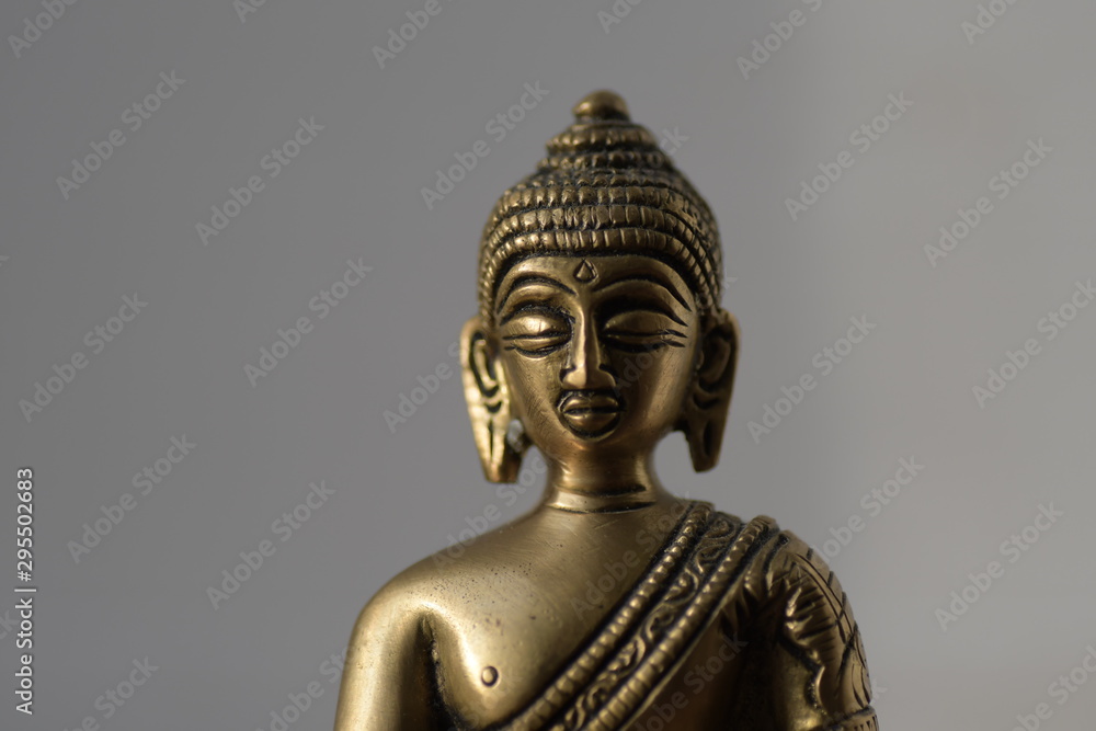 torso bronze buddha statue mit geschlossenen augen vor grauem hintergrund