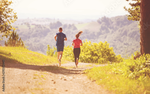 young couple jogging on sunny day at nature