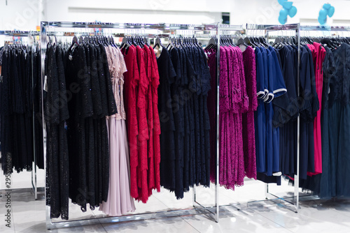 lot of women evening dresses on a hanger in the store