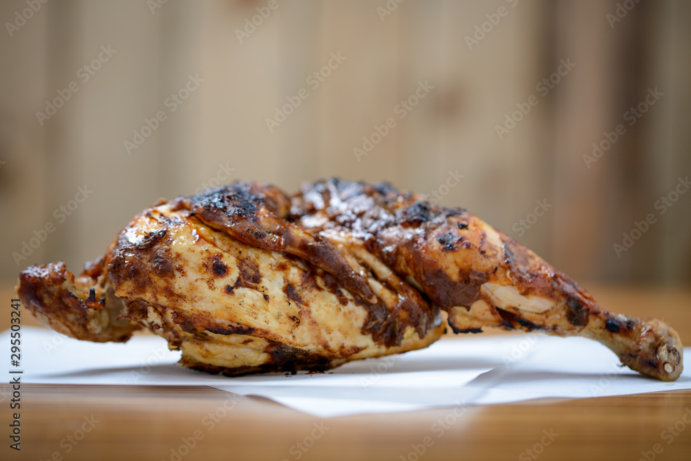 Half a grilled jerk chicken on table with copy space Half a grilled jerk chicken on table with copy space