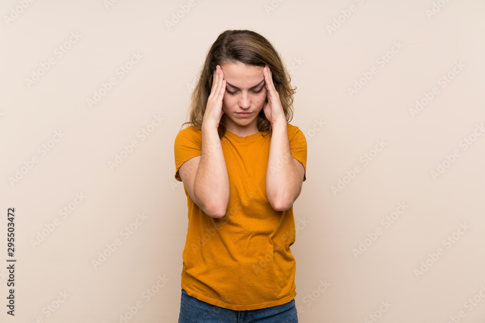 Young blonde girl over isolated background with headache Young blonde girl over isolated background with headache