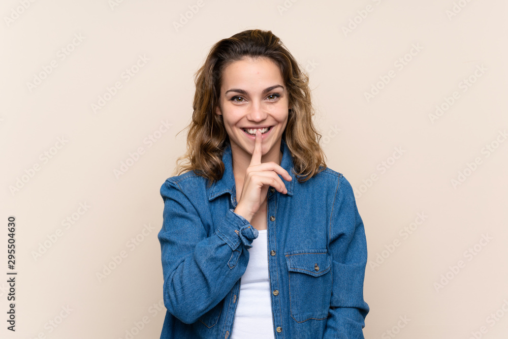 Young blonde woman over isolated background doing silence gesture Young blonde woman over isolated background doing silence gesture