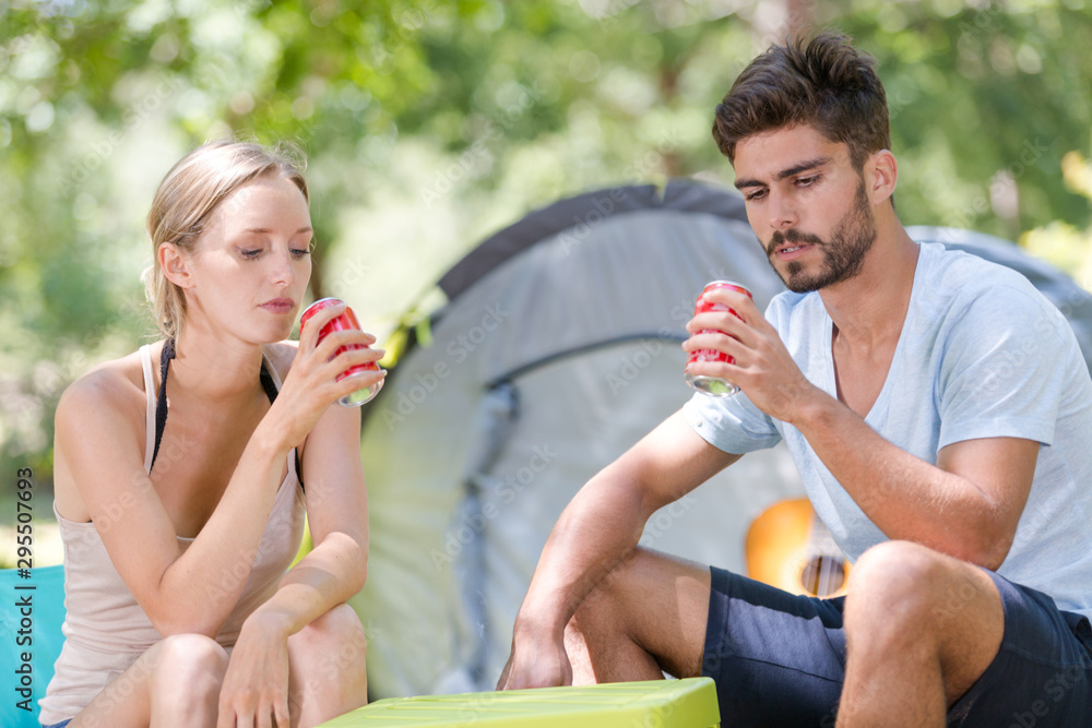 Obraz premium happy young couple camping drinkig coke