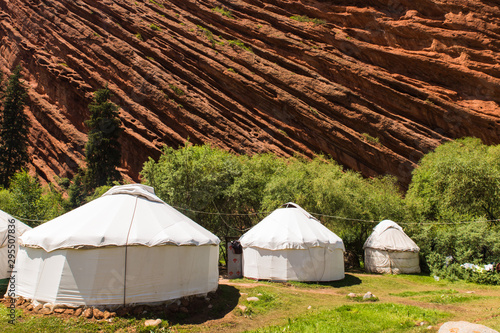 three white yurt houses at seven bulls Jeti Ogyz valley red sandstone formation in Kyrgyzstan