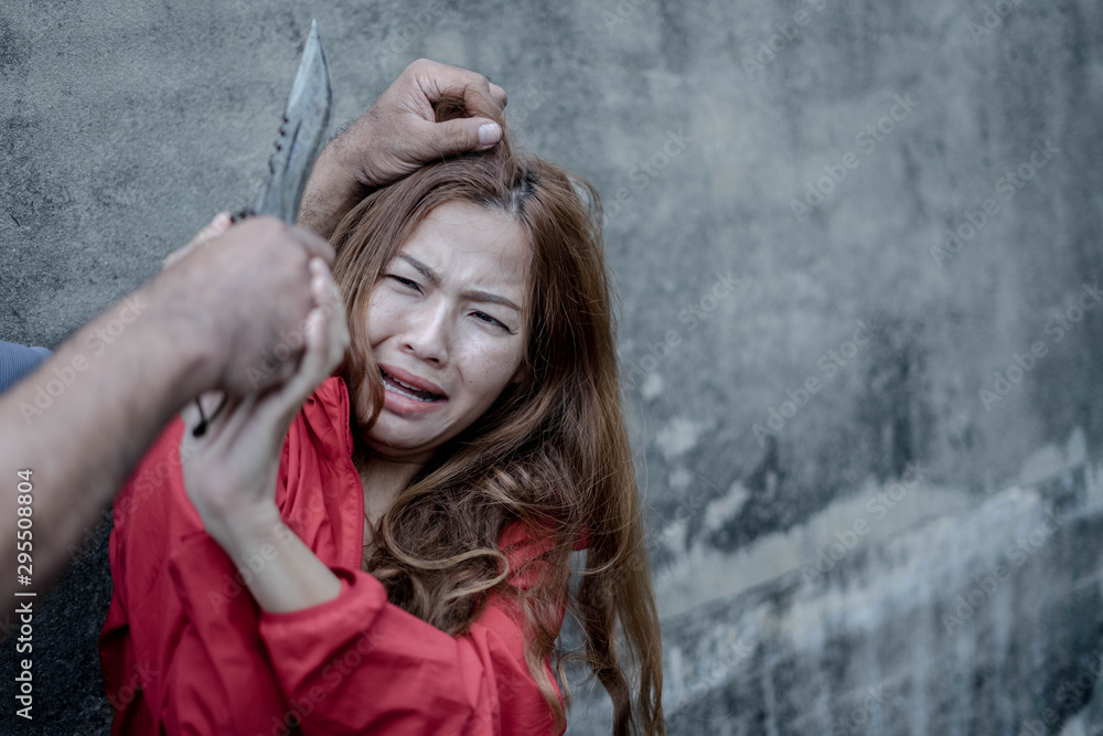 Fototapeta premium A knife in the hands of a cruel man, Criminals using violence to intimidate women, intimidating and imprisoning a woman, Stopping violence women concept.