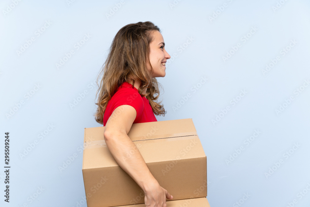 Young blonde woman holding a box to move it to another site in lateral position Young blonde woman holding a box to move it to another site in lateral position