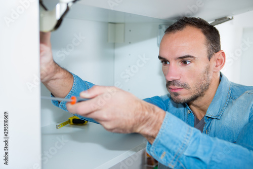 a man fitting a cupboard