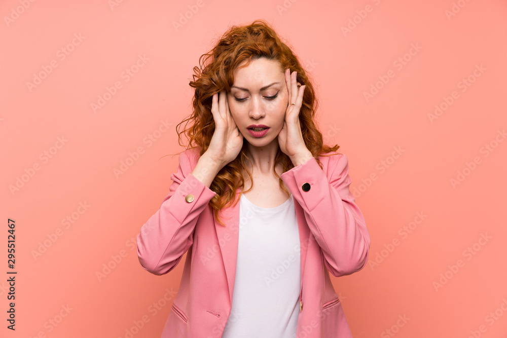 Redhead woman in suit over isolated pink wall unhappy and frustrated with something. Negative facial expression Redhead woman in suit over isolated pink wall unhappy and frustrated with something. Negative facial expression