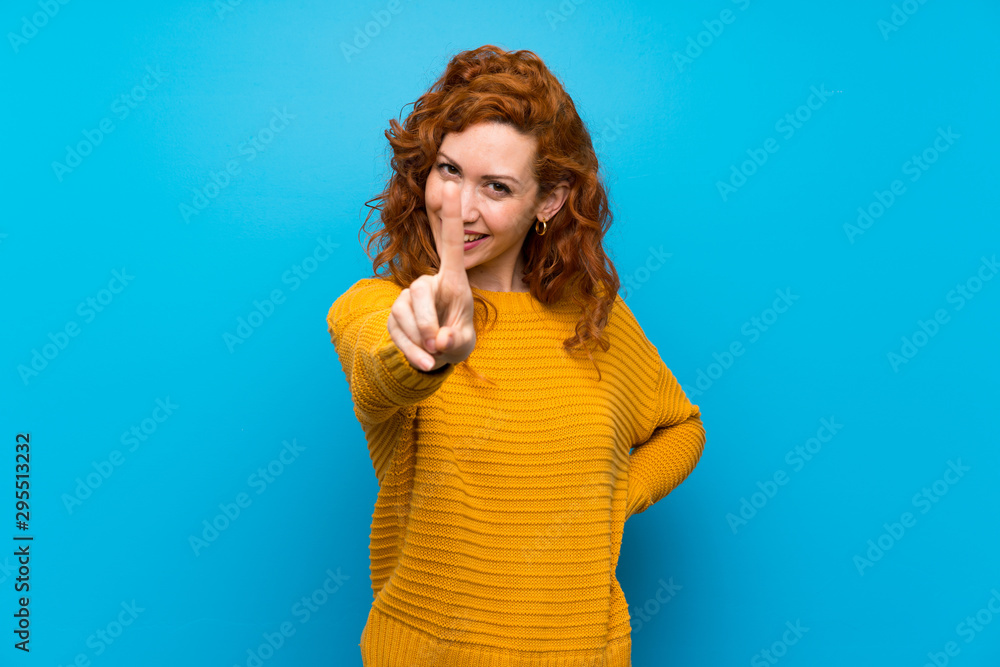 Redhead woman with yellow sweater showing and lifting a finger Redhead woman with yellow sweater showing and lifting a finger