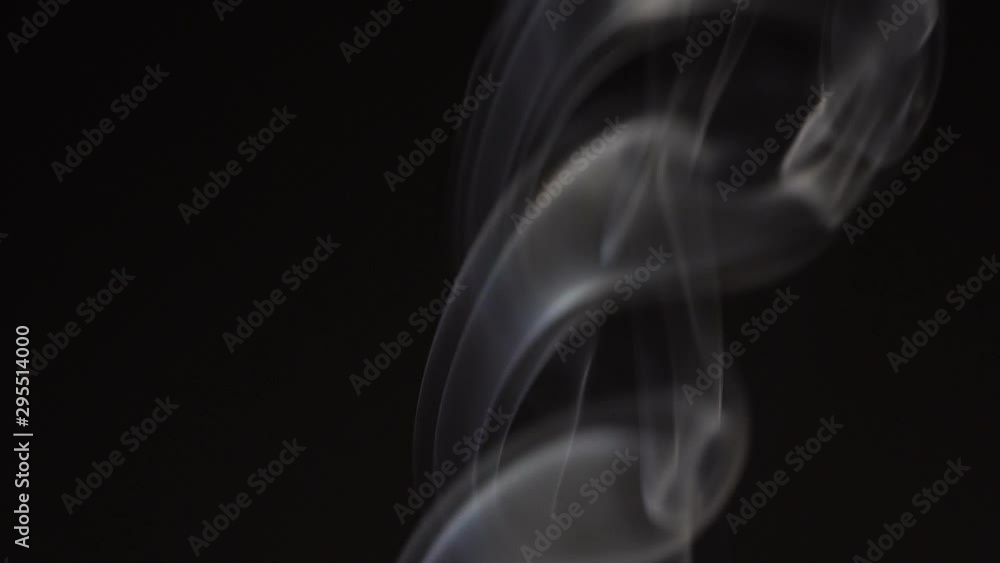 White smoke on black background in slow motion. White steam spins and rises White smoke on black background in slow motion. White steam spins and rises