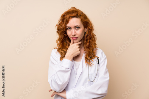 Redhead doctor woman standing and thinking an idea © luismolinero