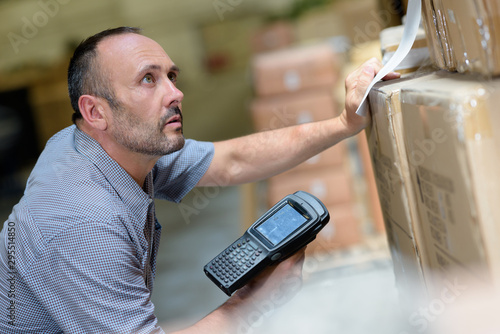 worker with portable barcode scanner in warehouse photo