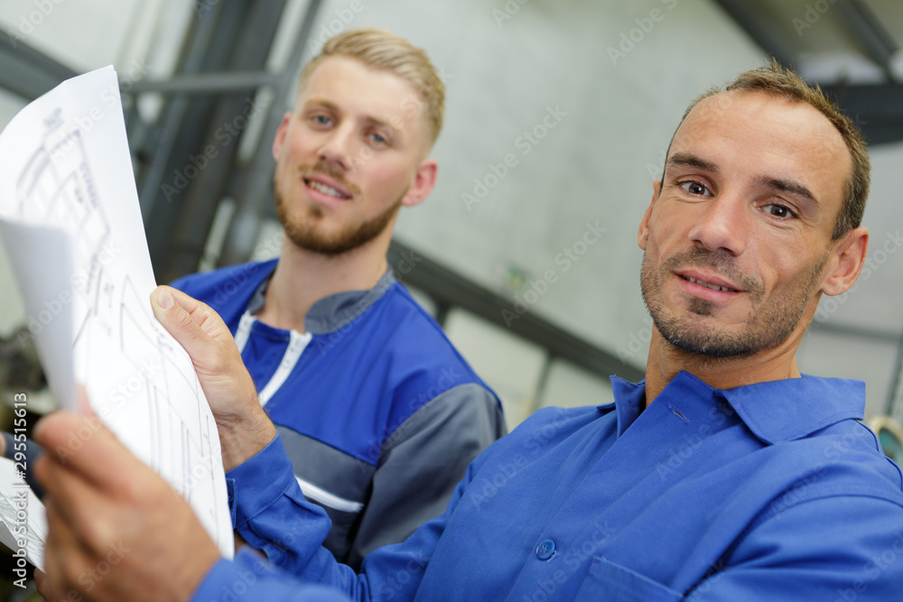 Fototapeta premium two workers wearing in blue uniform looking at the camera