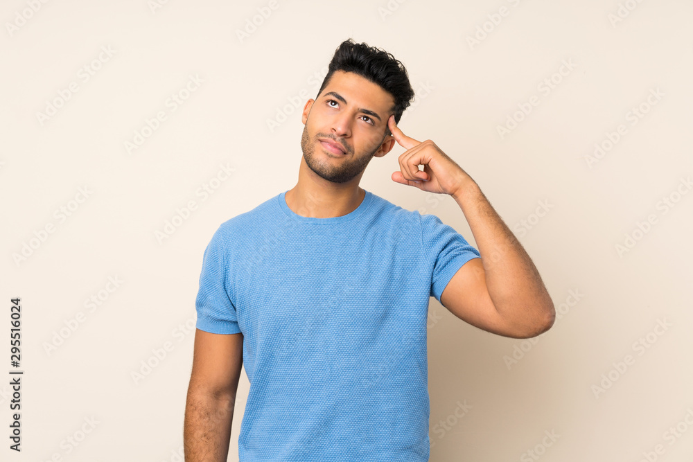 Young handsome man over isolated background making the gesture of madness putting finger on the head Young handsome man over isolated background making the gesture of madness putting finger on the head