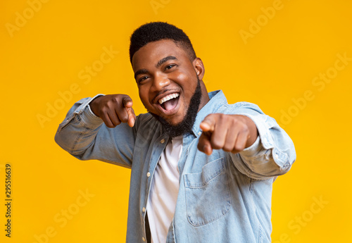 Cheerful african american man pointing fingers at camera