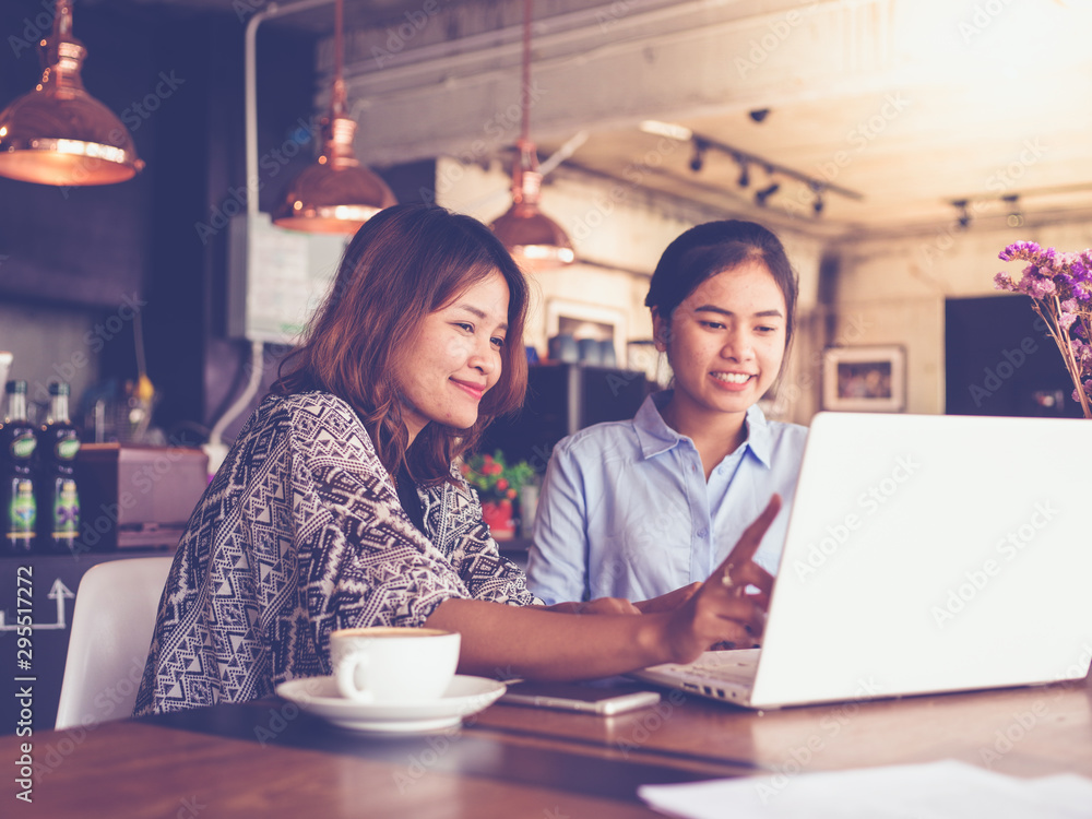 Asian business girl working and drinking coffee in cafe with laptop Asian business girl working and drinking coffee in cafe with laptop