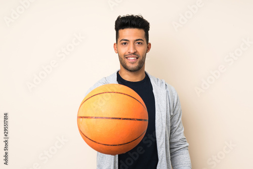 Young handsome man over isolated background with ball of basketball
