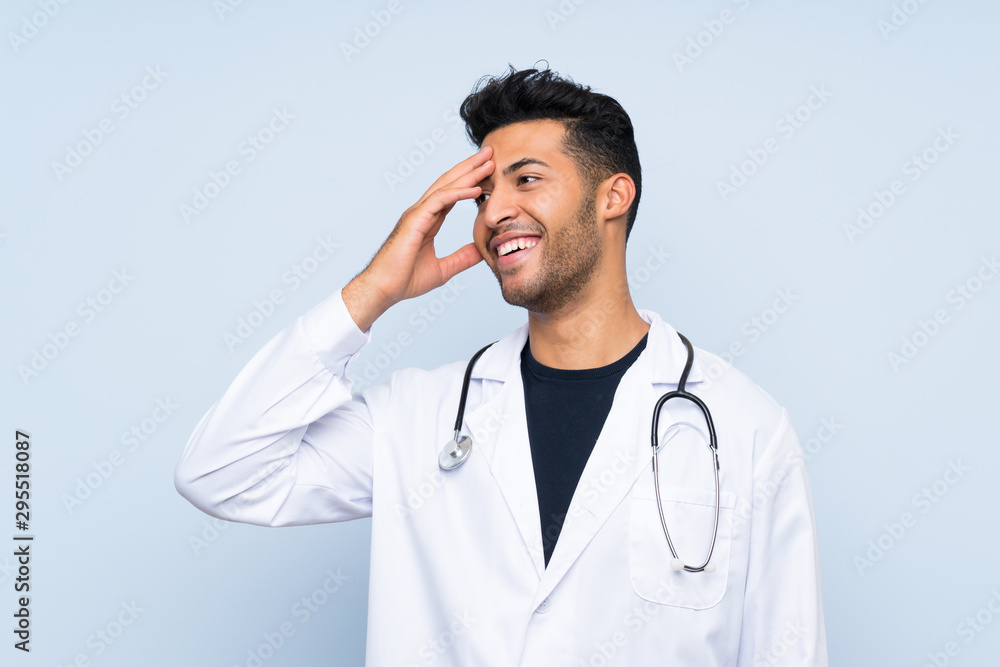 Young doctor man over isolated blue wall has realized something and intending the solution Young doctor man over isolated blue wall has realized something and intending the solution