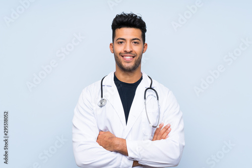 Valokuva Young doctor man over isolated blue wall smiling a lot