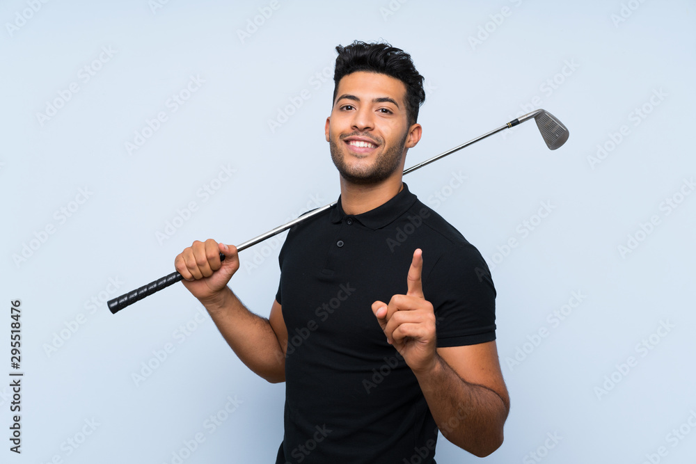 Handsome young man playing golf over isolated blue background pointing up a great idea Handsome young man playing golf over isolated blue background pointing up a great idea
