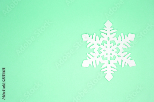 Felt snowflake on a green background. Place for text. Christmas concept © Oksana