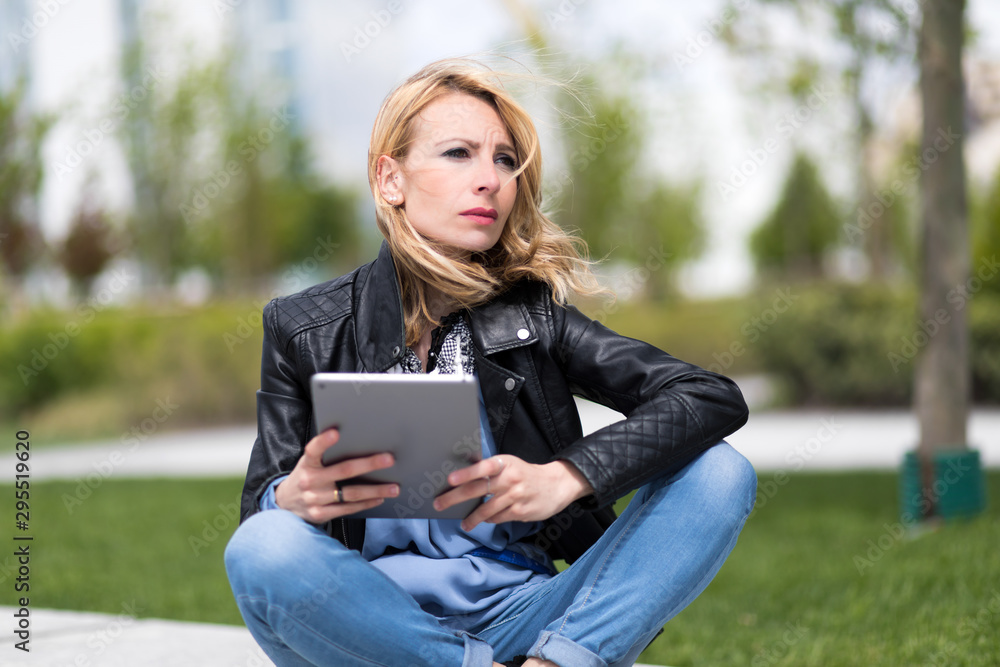 Girl with tablet sitting on a park bench Girl with tablet sitting on a park bench