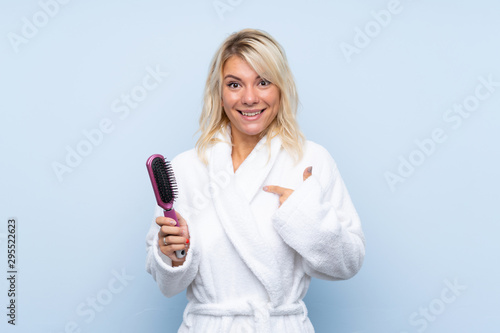 Young woman in a bathrobe with hair comb with surprise facial expression