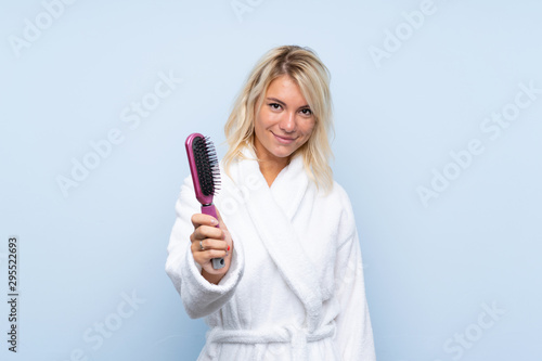 Young woman in a bathrobe with hair comb with happy expression