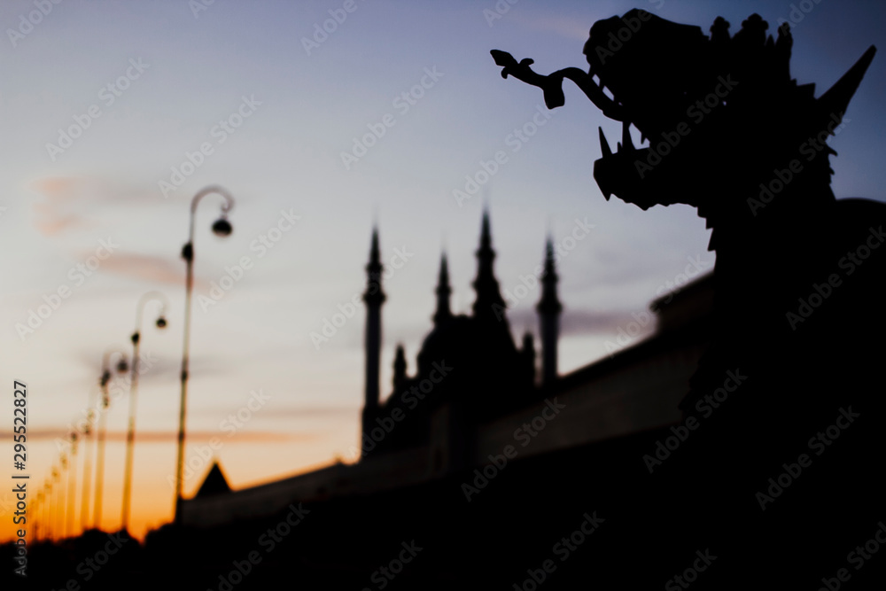 Silhouette of Kul Sharif mosque and dragon at sunset.