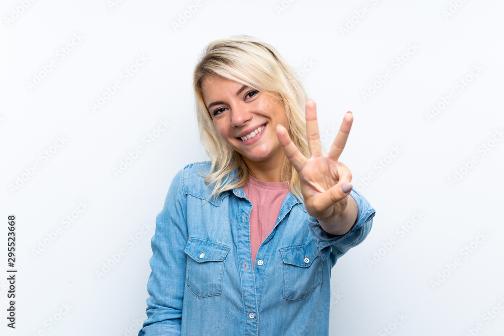 Young blonde woman over isolated white background happy and counting three with fingers Young blonde woman over isolated white background happy and counting three with fingers