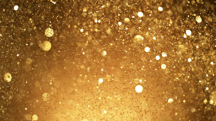Abstract golden glittering background with blur dots.