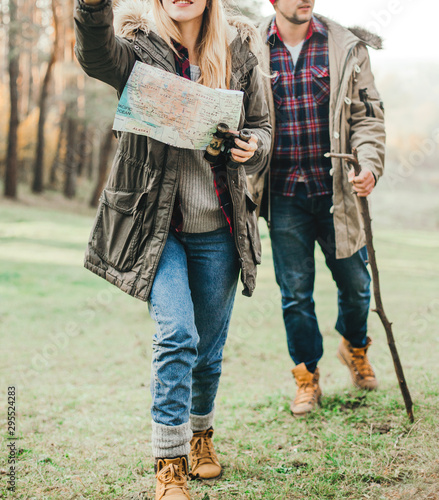 Travel couple with map, compass and backpack in the forest. Freedom and active travel concept.