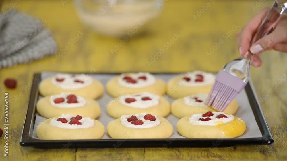 Woman cooks in the kitchen sweet open buns with cottage cheese, raspberries and shtreyzelem. The concept of homemade pastry, cooking buns vatrushka. Woman cooks in the kitchen sweet open buns with cottage cheese, raspberries and shtreyzelem. The concept of homemade pastry, cooking buns vatrushka.
