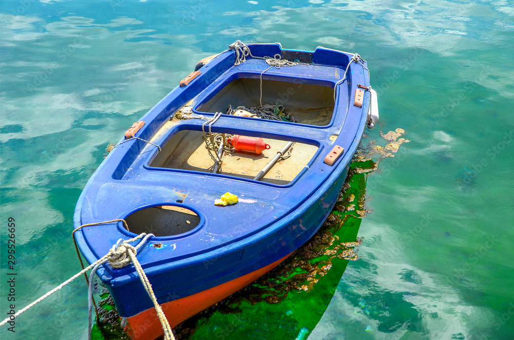 Small fishing boat floating in green waters