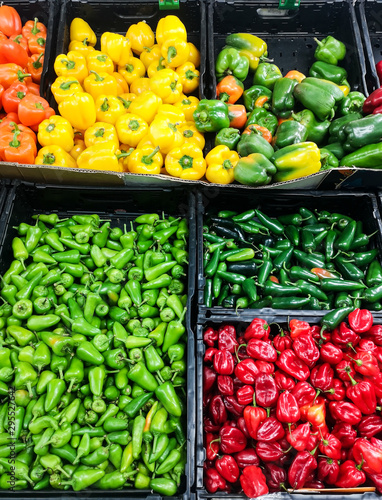 Assorted pepper in black boxes at market  green  red  yellow and orange colored