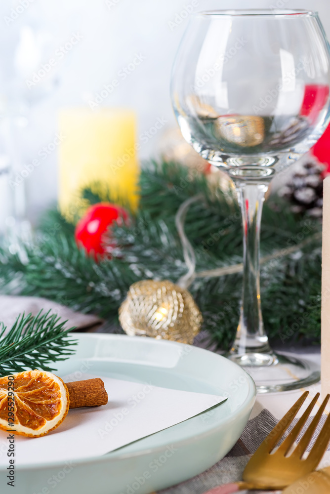 Festive Christmas and New Year details table setting with dry orange and wine glass on a gray textile. Dining place decorated Festive Christmas and New Year details table setting with dry orange and wine glass on a gray textile. Dining place decorated