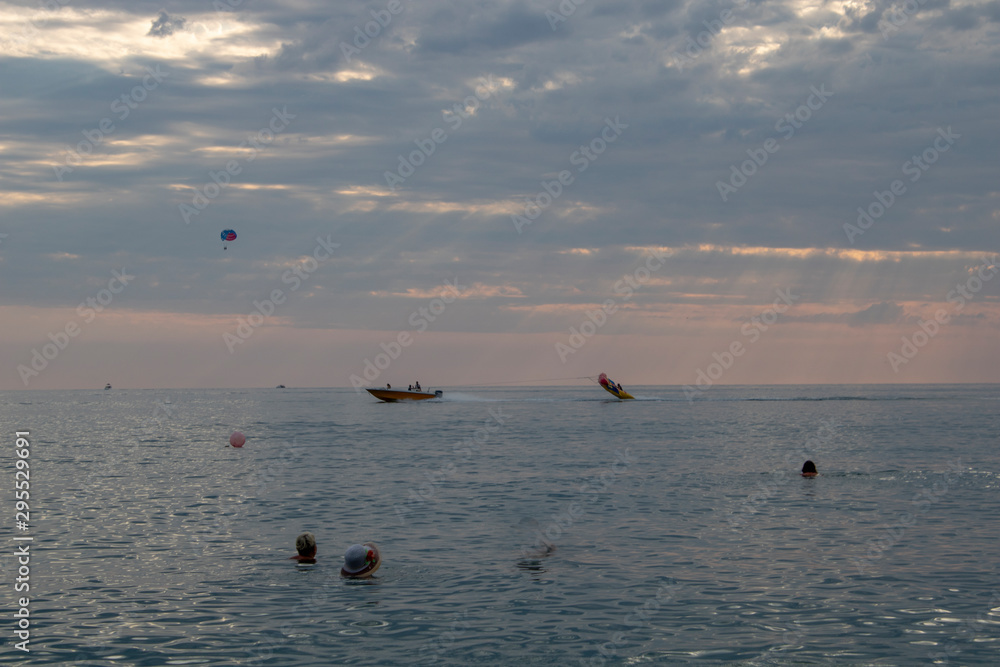 Riding an inflatable banana and parachute over the Black Sea in the evening