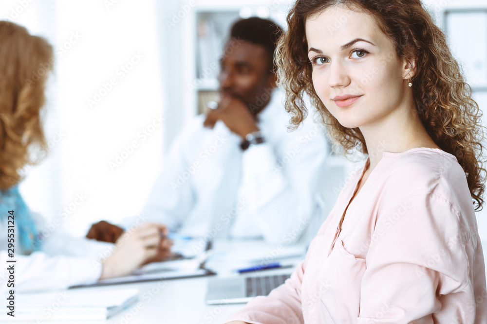 Fototapeta premium Business woman at meeting in office, colored in white. Multi ethnic business people group