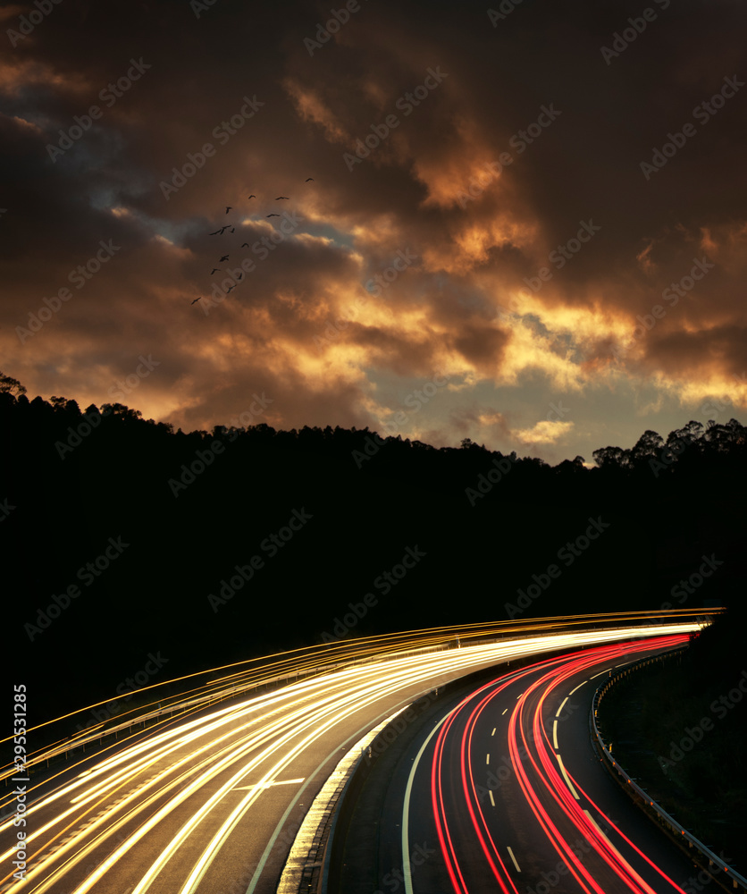 Curve on a street with light trails of the cars passing by