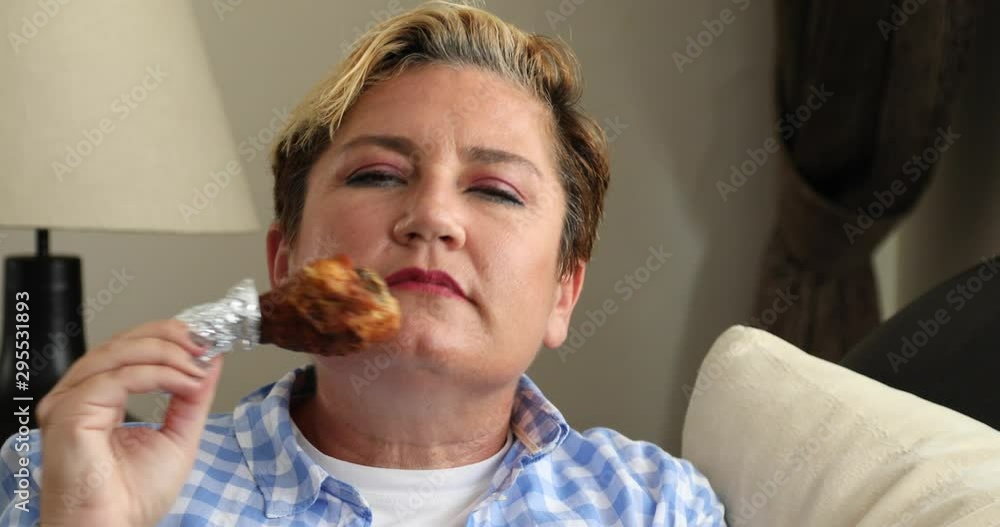 Portrait of a caucasian middle aged woman sitting on sofa and eating low calorie food. Diet. Dieting concept. Healthy Food. Portrait of a caucasian middle aged woman sitting on sofa and eating low calorie food. Diet. Dieting concept. Healthy Food.