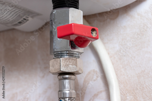 Red metal sanitary valve that provides hot water supply from a water heater, boiler