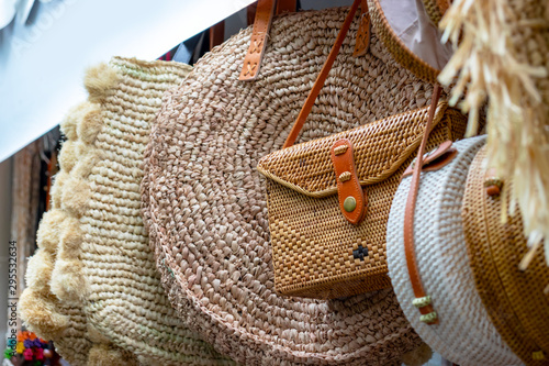 Balinese traditional handmade rattan woven round shoulder bags with leather handles at a souvenir street shop. Bali, Indonesia photo