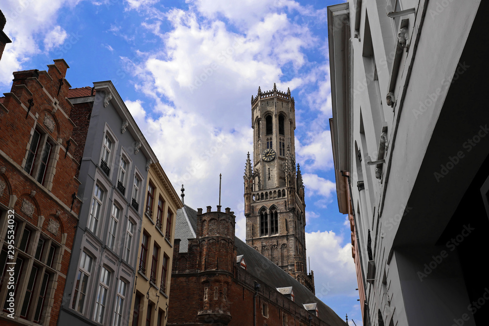 Obraz premium The tower of belfry and traditional buildings with ancient lamp post , Bruges, Belgium