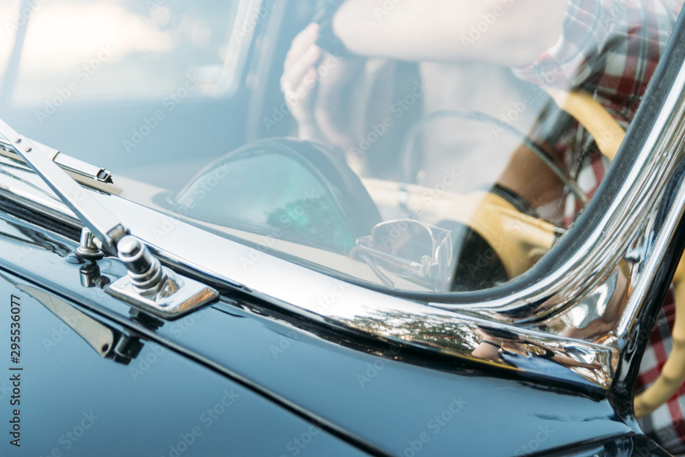 Obraz premium the man is sitting at the wheel, the driver. view from the rear window. Rear view of tourist guy in car. Travel and summer vacation concepts.