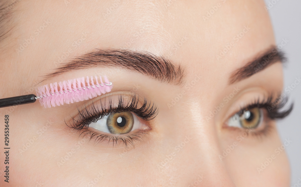 Obraz premium Beautiful Woman with long eyelashes in a beauty salon. Eyelash extension procedure. Cosmetology skin care