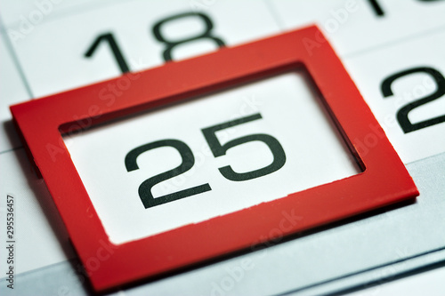 twenty-fifth of the month highlighted on the calendar with a red frame close-up macro, mark on the calendar, twenty-fifth date