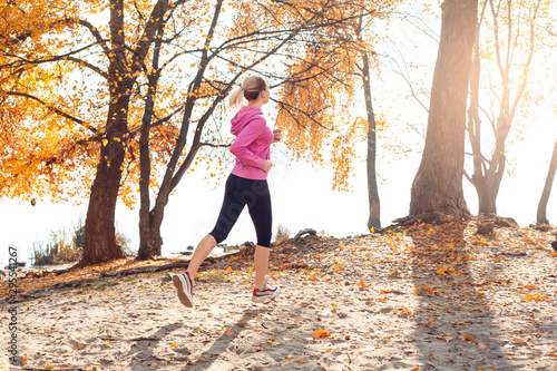 Healthy Lifestyle. Young woman jogging outdoors autumn season motion back view © Viktoriia