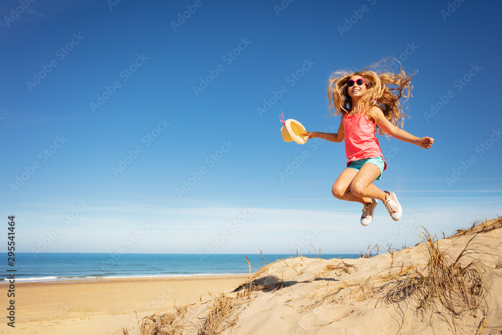 Cute beautiful girl with straw hat jump over beach Cute beautiful girl with straw hat jump over beach